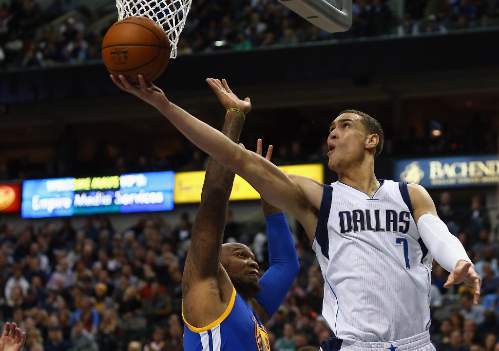 Dwight Powell, pemain Dallas Mavericks yang melakukan tembakan coba dihalangi pebasket Golden State Warriors Marreese Speights (Foto:  Ronald Martinez/Getty Images/AFP)
