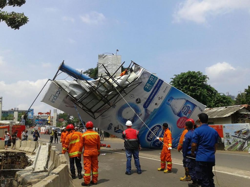Petugas Damkar Kebayoran Baru tengah merobohkan papan raklame yang roboh,--Foto: MTVN/Eko Nordiansyah