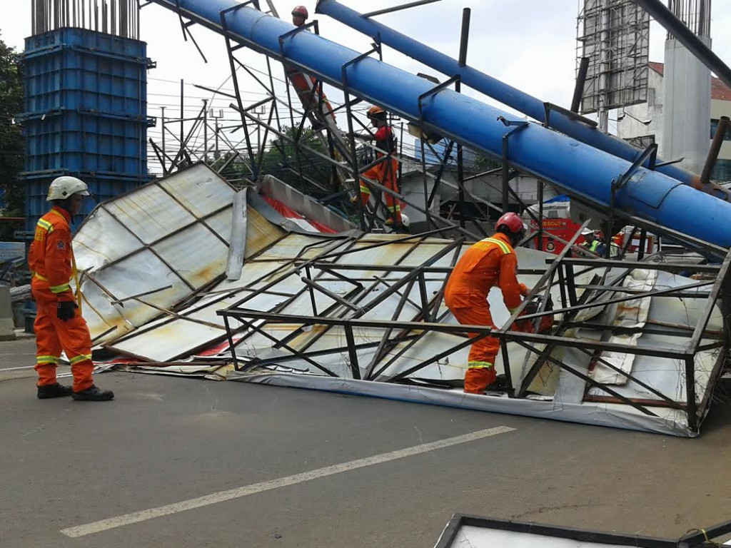 Petugas Dakmar Kebayoran Baru memotong papan reklame yang roboh di Jalan Kapten Tendean pagi tadi,--Foto: MTVN/Eko Nordiansyah