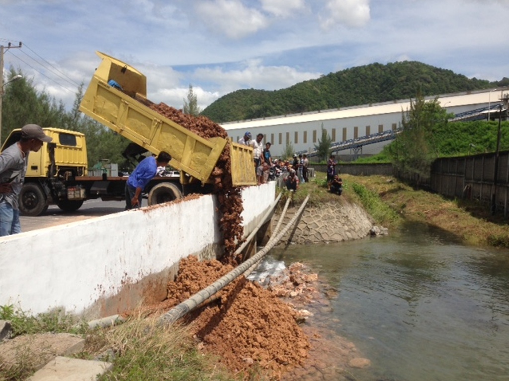 Warga Lhoknga membendung aliran sungai yang mengalir di depan PT Lafarge Semen Indonesia dengan batu dan tanah. MTVN/Nurul Fajri.