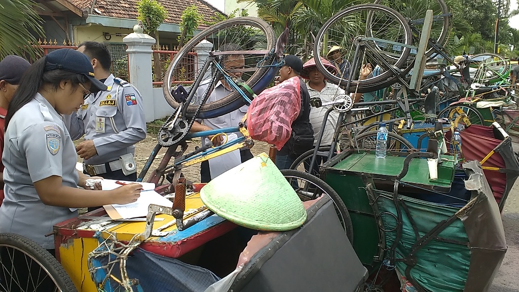 Petugas Dinas Lalu Lintas dan Angkutan Jalan Kota Bogor memeriksa kondisi becak di Jalan Mayor Oking, Selasa (16/02/2016). (Metrotvnews.com/Mulvi M Noor)