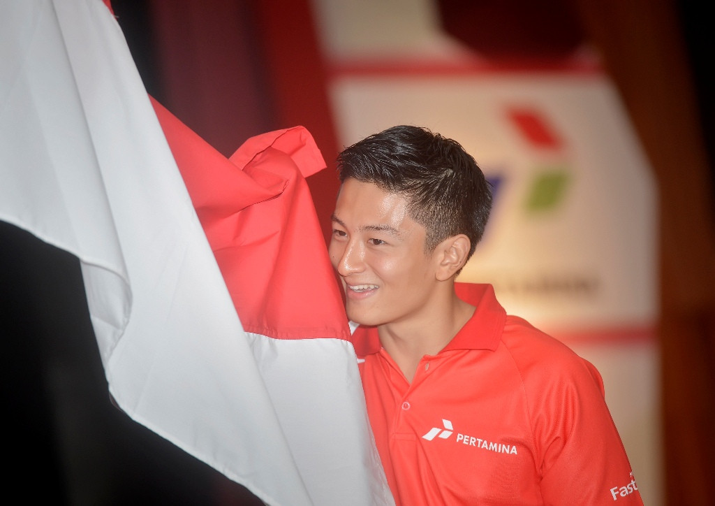 Rio Haryanto mencium bendera Merah Putih sebagai tanda kesiapannya membawa nama bangsa di pentas F1 (Foto: ANTARA FOTO/Yudhi Mahatma)