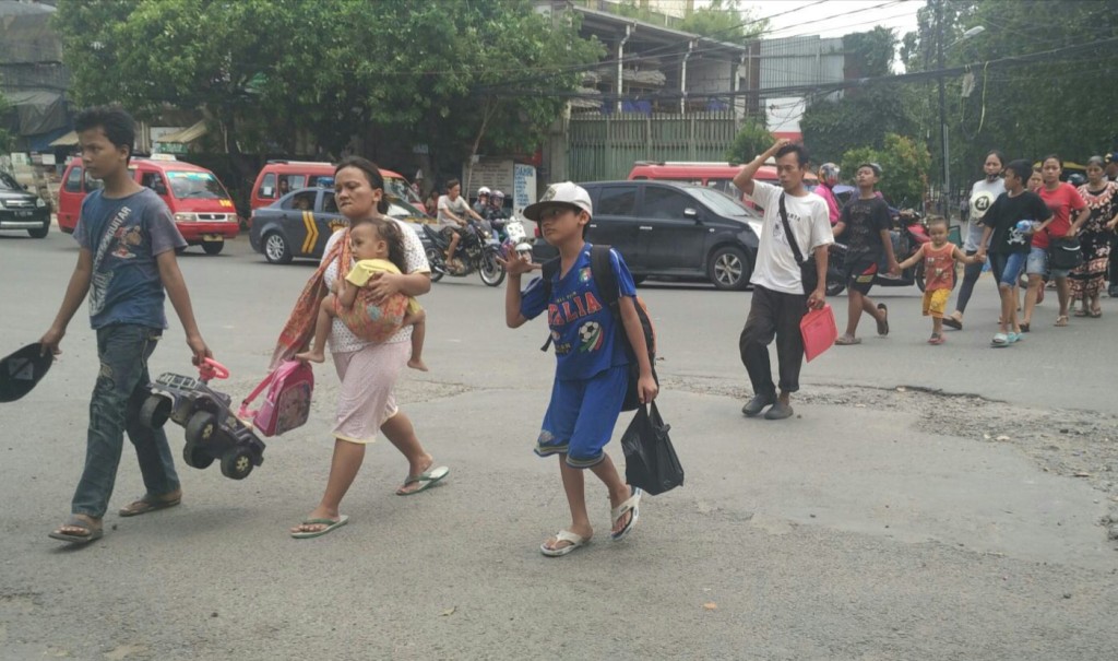Warga Kalijodo menuju kendaraan yang akan mengangkut mereka pindah ke Rusunawa Marunda, Minggu (21/2/2016). Foto: MTVN/Arga Sumantri