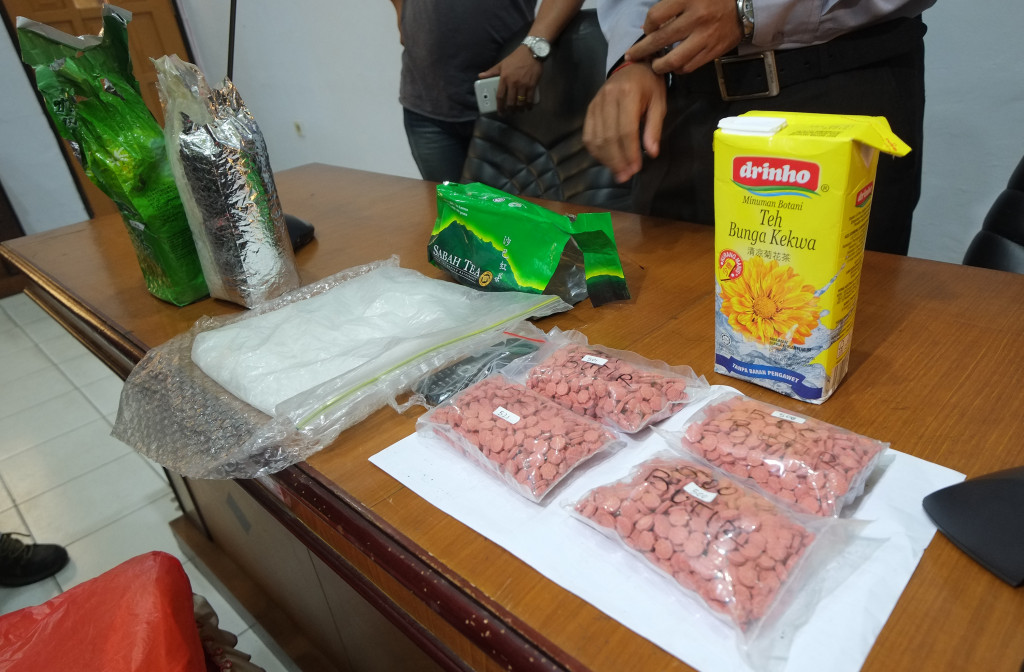 Anggota kepolisian memperlihatkan barang bukti berupa sabu seberat 1,5 Kg dan pil exctasy sebanyak 2.021 butir beserta barang bukti lainnya di ruang pertemuan Polres Tarakan, Kalimantan Utara. (foto: Antara/Fadlansyah)