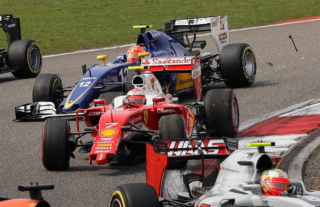 Pembalap Ferrari Kimi Raikkonen tetap melaju meski sayap kiri mobilnya mengalami kerusakan. (AP Photo/Andy Wong)