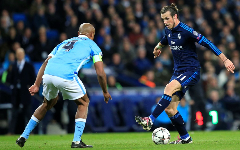 Gareth Bale (Kanan) berusaha melewati adangan Vincent Kompany (Kiri) (Foto: AP/Jon Super)