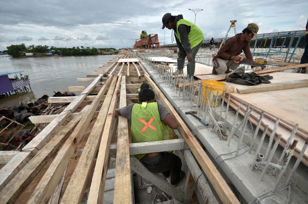 Pekerja menyelesaikan pembangunan jembatan sungai Tallo yang berada di ruas jalan Tol Reformasi Seksi IV, Makassar, Sulawesi Selatan. (ANTARA FOTO/Dewi Fajriani)