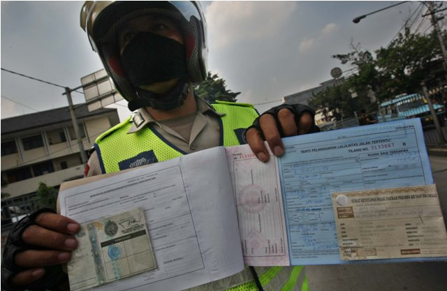  Polisi menunjukkan bukti tilang kendaraan pribadi dan motor yang melewati jalur busway. Foto: MI/Ramdani
