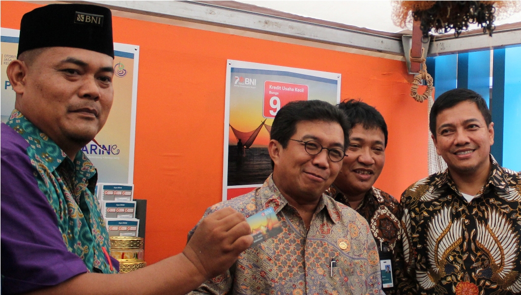 Agen Laku Pandai BNI Masuri (kiri) menunjukkan Kartu Jaring BNI kepada Ketua DK-OJK Muliaman D Hadad (kedua dari kiri) (Foto: dokumentasi BNI)