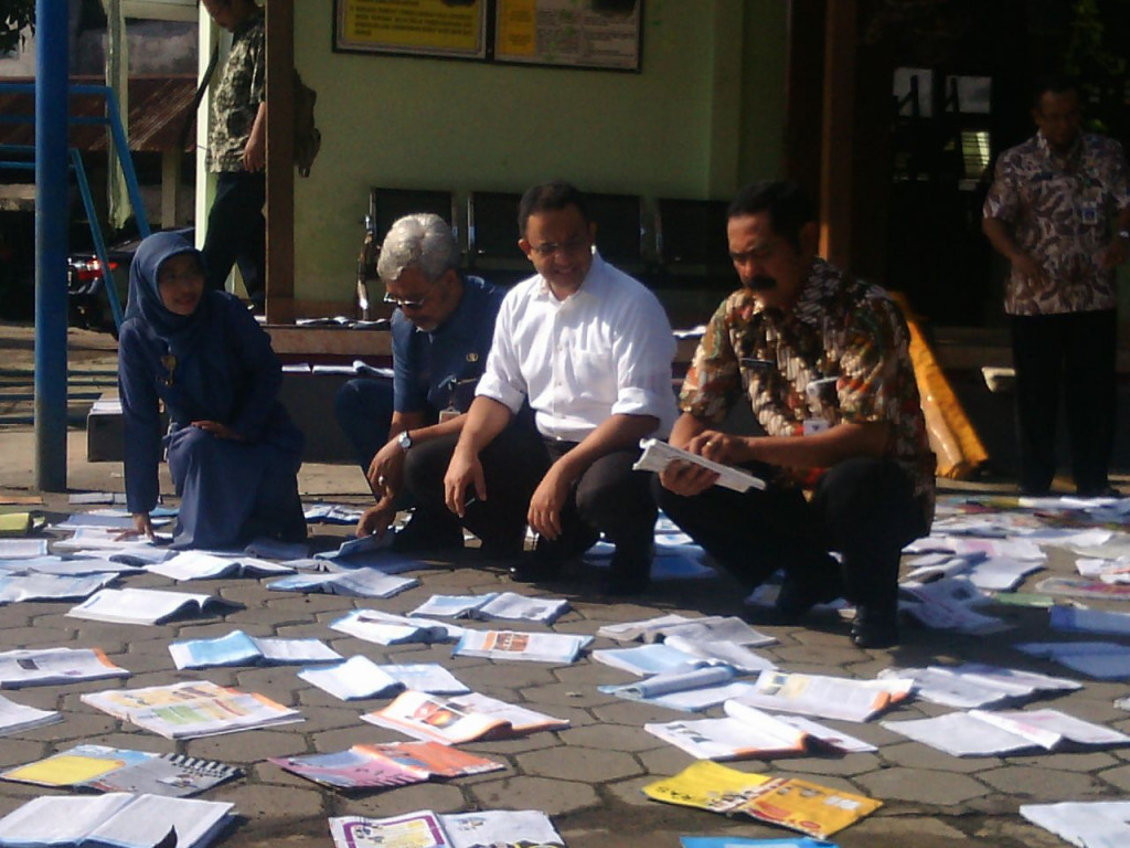 Menteri Anies (baju putih) dan Wali Kota Solo Hadi Rudyatmo (paling kanan) melihat sejumlah buku perpustakaan di SMP 6 Solo yang dijemur setelah terndam banjir, Selasa (21/06/2016). (Metrotvnews.com/Pythag Kurniati)