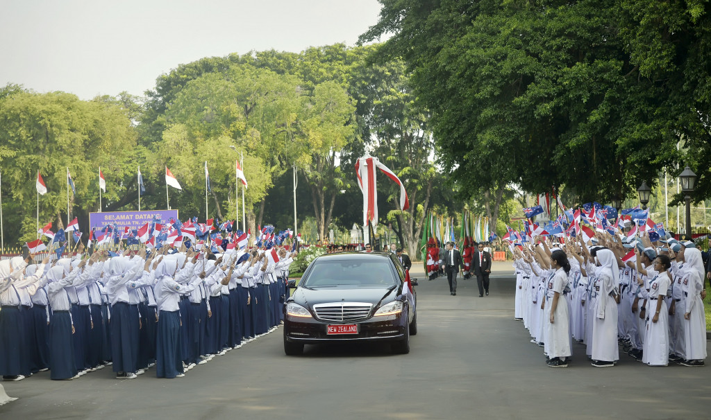  Siswa SMP dan SMA melambaikan bendera RI dan Selandia Baru saat mobil yang membawa Perdana Menteri Selandia Baru John Key melintas di halaman Istana Merdeka, Jakarta, Senin 18 Juli 2016. Antara Foto/Yudhi Mahatma