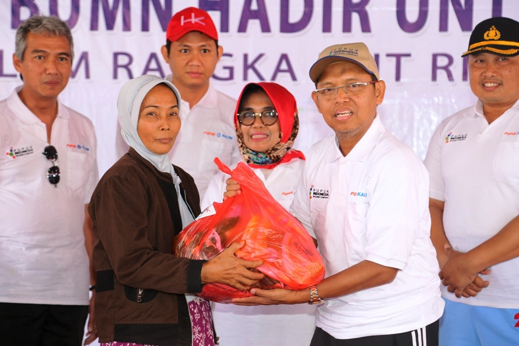 Direktur SDM & Tata Kelola menyerahkan  sembako pada kegiatan Pasar Murah BUMN di Bontang (Foto:Dok)