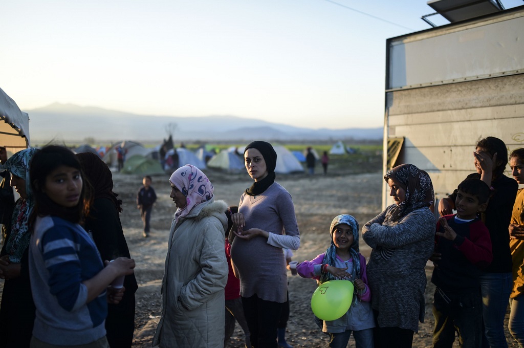 Para pengungsi asal Timur Tengah menanti makanan di perbatasan Yunani dan Macedonia, 31 Maret 2016. (Foto: AFP/BULENT KILIC)