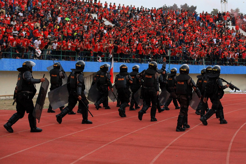 Personel kepolisian menjaga keamanan ketika pertandingan sepak bola berlangsung. (Foto: Ant/Maulana Surya)