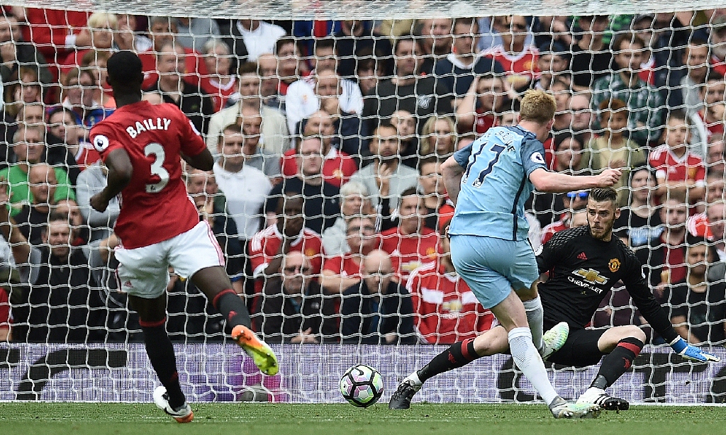 Proses gol pertama Manchester City lewat Kevin De Bruyne ke gawang Manchester United yang dikawal David De Gea (Oli SCARFF / AFP)