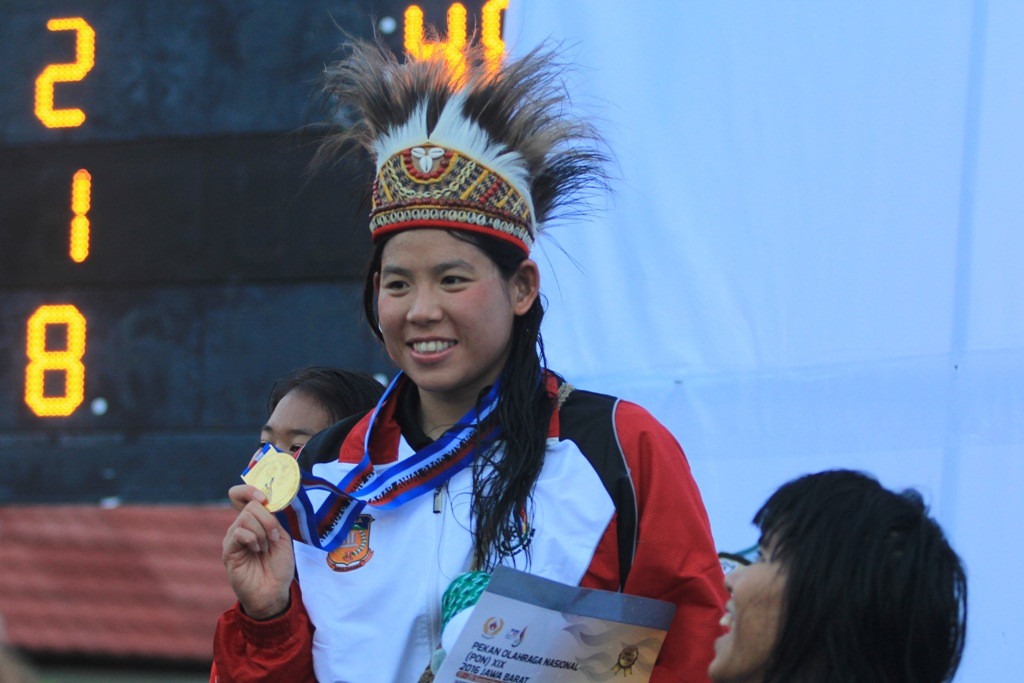 Atlet Selam Papua Margaretha Herawati menunjukan medali emas yang diraihnya usai menyelesaikan nomor 100 meter Bifins putri cabang Selam Kolam PON XIX di kolam renang Catherine, Cirebon, Jumat (16/9). (Antara Foto)