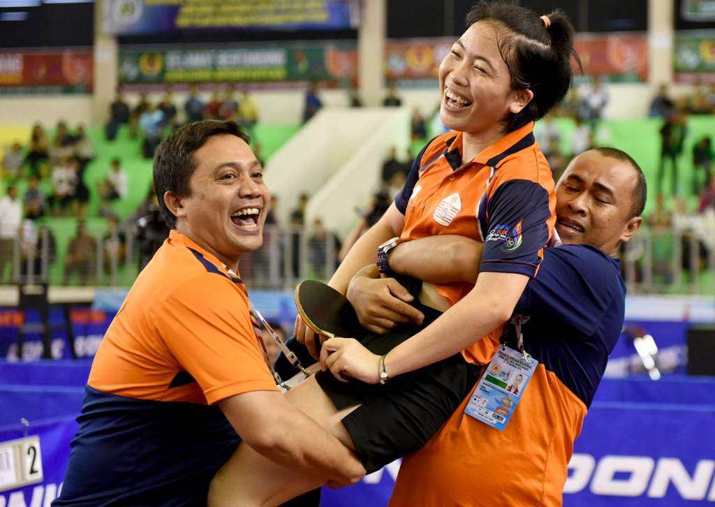 Petenis meja putri DKI Jakarta Stella Priska Palit diangkat oleh kedua pelatihnya Gatot (kanan) dan Zaenudin (kiri) (Foto: Antara/Hermanus Prihatna)