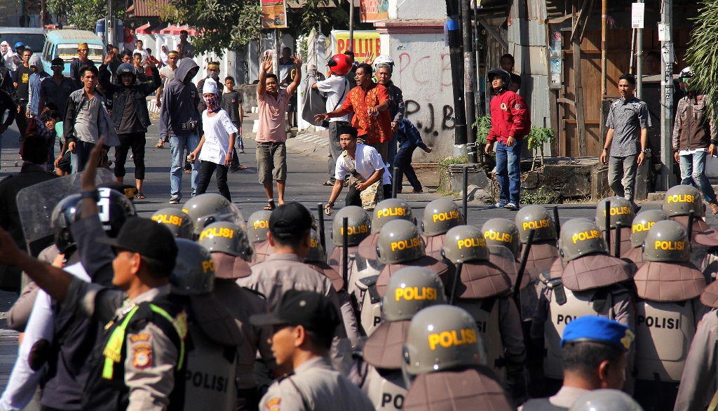 Anggota polisi berusaha membubarkan warga saat terjadi bentrok antarwarga di Kawasan Balla Lompoa, Kabupaten Gowa, Sulawesi Selatan, Senin (12/9/2016). Foto: Antara/Abriawan Abhe