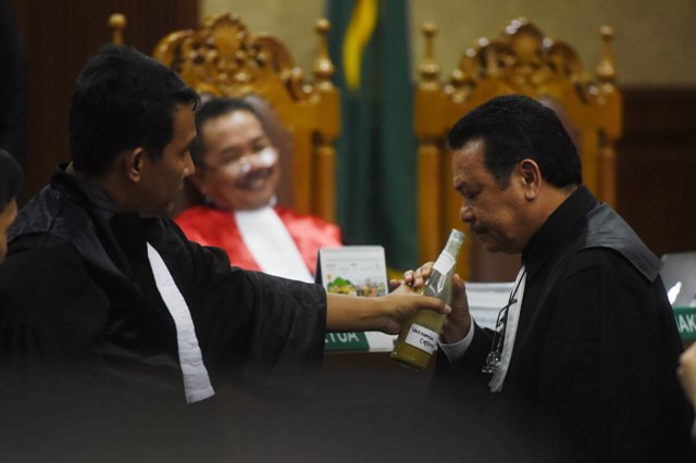 Jaksa Penuntut Umum dan penasihat hukum terdakwa Jessica Kumala Wongso mencium bau barang bukti kopi Vietnam yang mengandung sianida dalam sidang kasus pembunuhan mirna di PN Jakarta Pusat, Jakarta, Rabu (13/7). Foto: Akbar Nugroho Gumay/Antara.