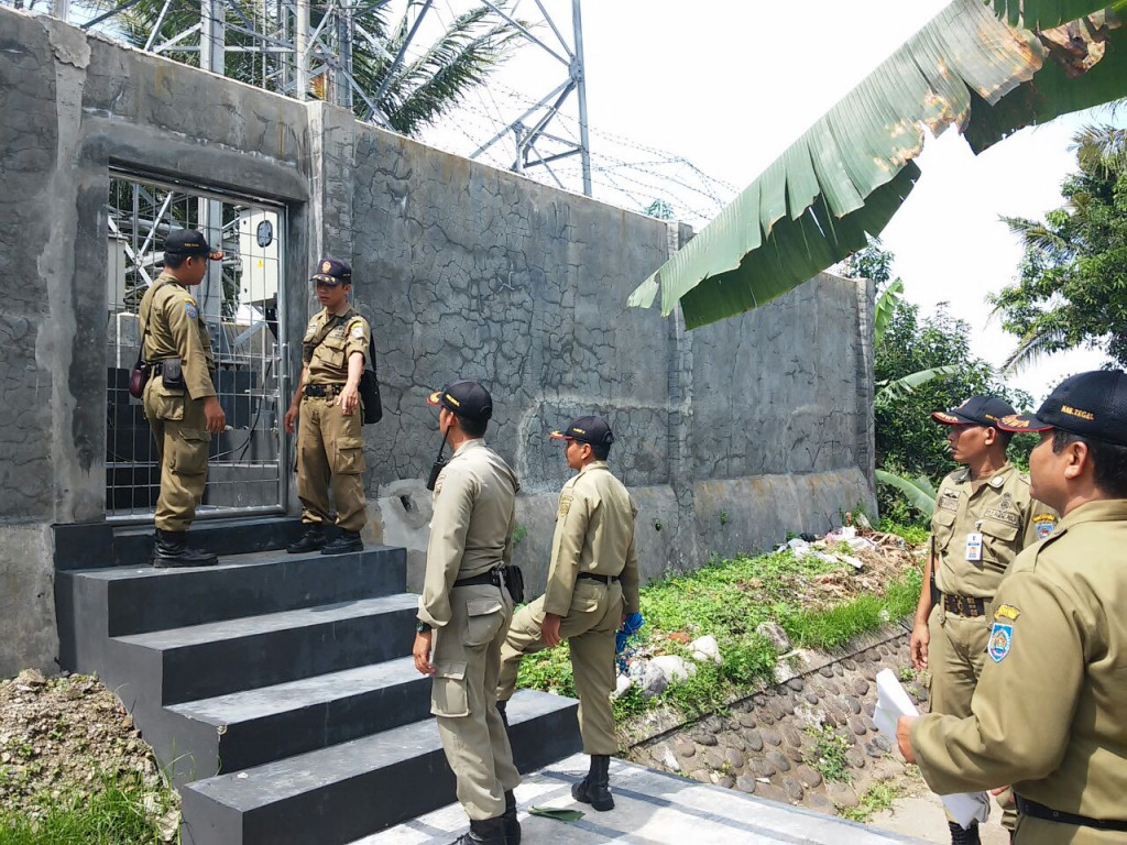 Sejumlah petugas Satpol PP Pemkab Tegal menyegel sebuah menara telekomunikasi di wilayah Kelurahan Slawi Kulon, Kecamatan Slawi, Kabupaten Tegal, Jawa Tengah. (Metrotvnews.com/Kuntoro Tayubi)