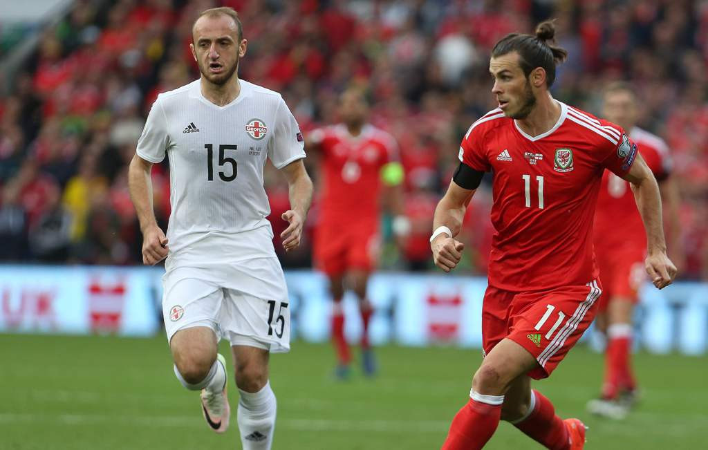 Valeri Gvilia berupaya mengadang pergerakan Gareth Bale (Kanan) (Foto: AFP/Geoff Caddick)