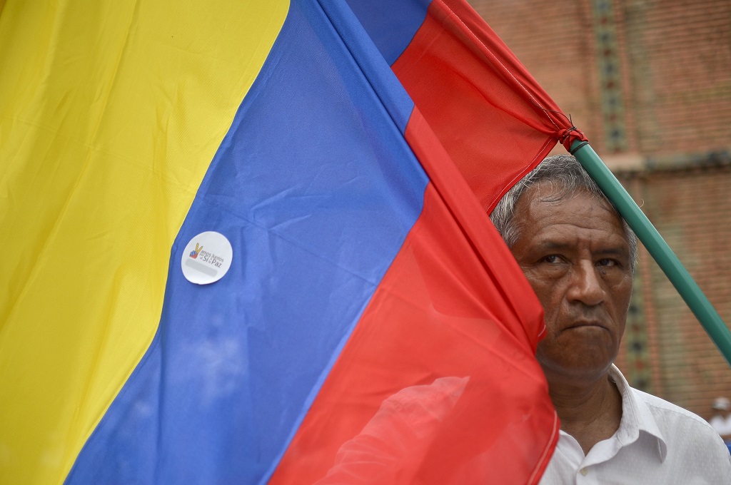 Seorang warga membawa bendera Kolombia dalam unjuk rasa damai di Cali, 9 Oktober 2016. (Foto: AFP/LUIS ROBAYO)
