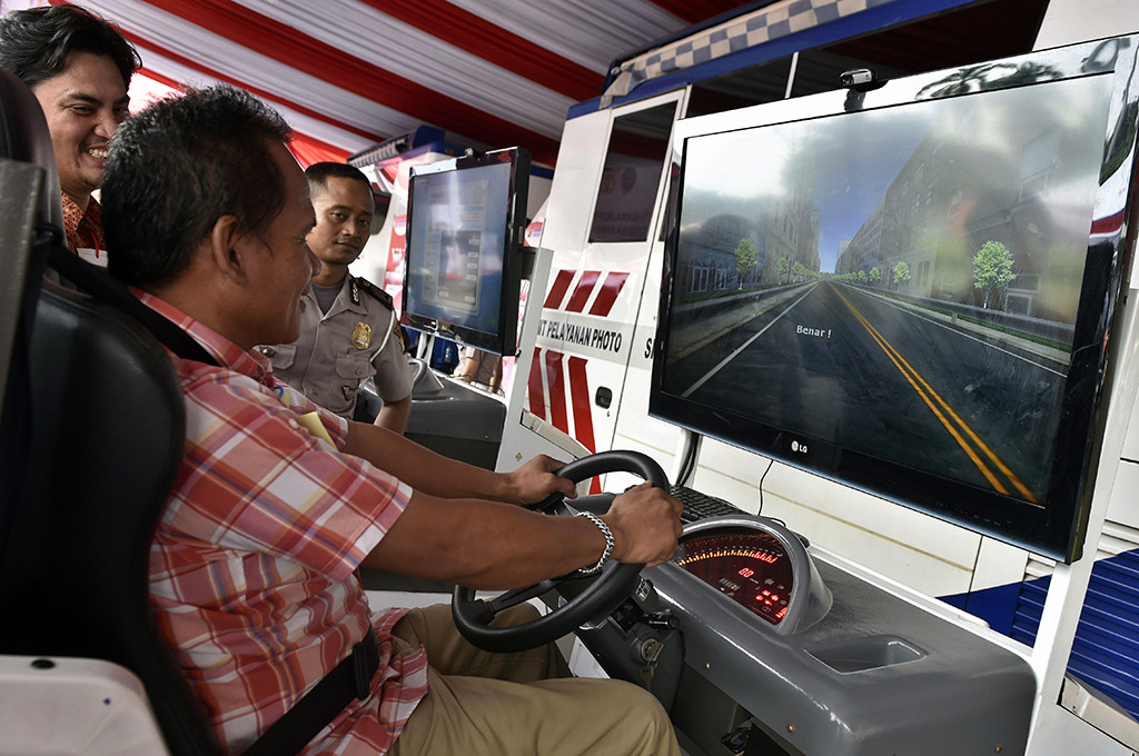 Peserta mengikuti tes mengemudi menggunakan simulator saat berlangsung layanan uji SIM A Umum dan KIR angkutan umum berbasis online di Silang Monas, Jakarta, Senin (15/8/2016) -- ANT/Puspa Perwitasari