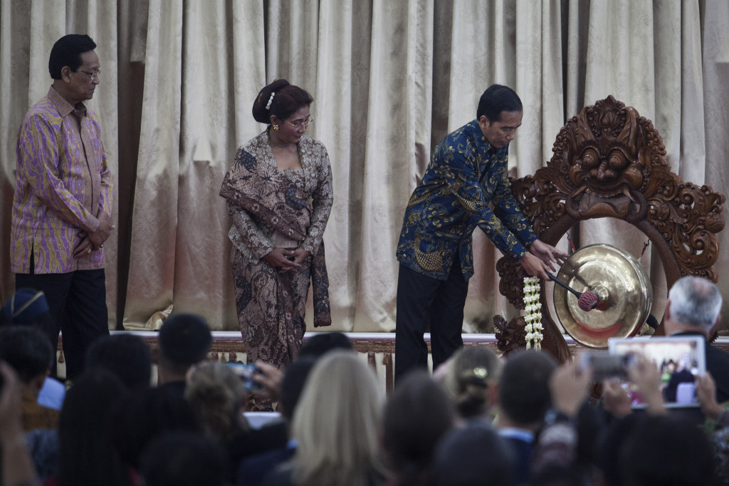 Presiden Jokowi (kanan) didampingi Menteri Kelautan dan Perikanan Susi Pudjiastuti (tengah) dan Gubernur DIY Sri Sultan HB X (kiri), memukul gong sebagai penanda pembukaan acara ‘The 2nd International Symposium on Fisheries Crime’ di Gedung Agung Istana K