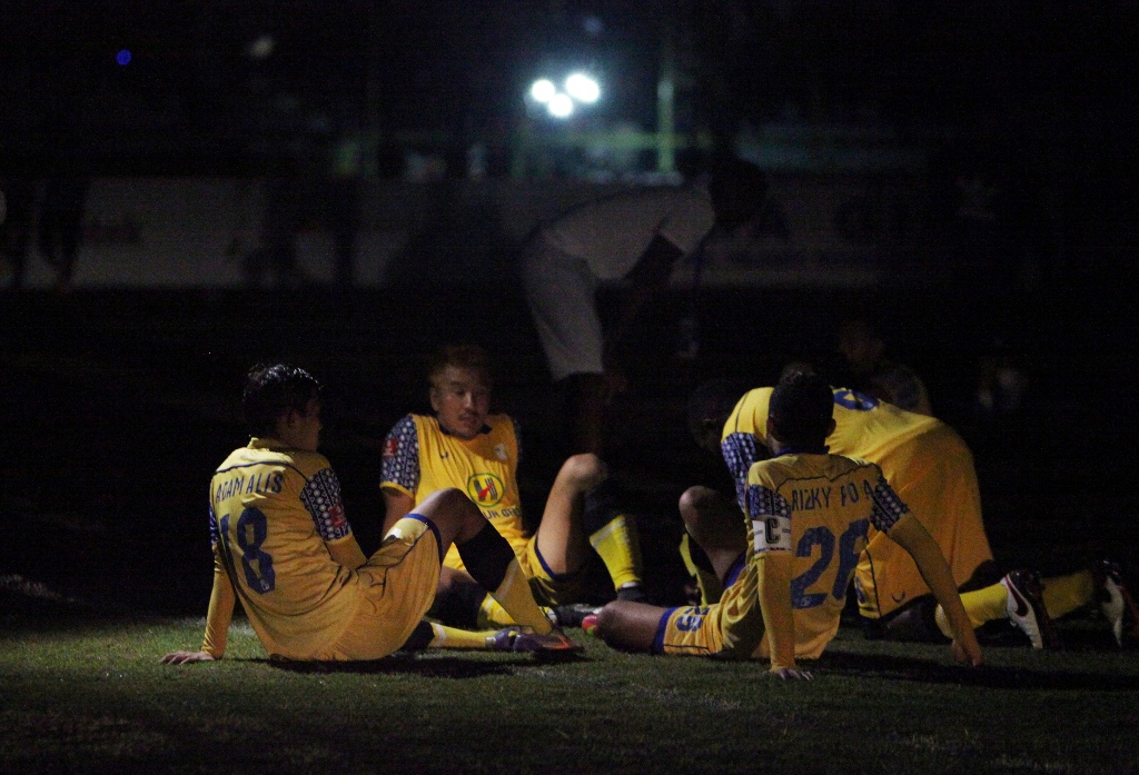 Pemain Barito Putera duduk di lapangan Stadion 17 Mei Banjarmasin menunggu lampu kembali menyala. (Antara Foto/Herry Murdy Hermawan)