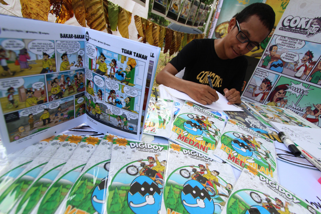 Komikus Dodi Pratama yang tergabung dalam komunitas Komik Digidoy Medan menampilkan hasil karyanya di Medan, Sumatera Utara.  (ANTARA FOTO/Septianda Perdana)