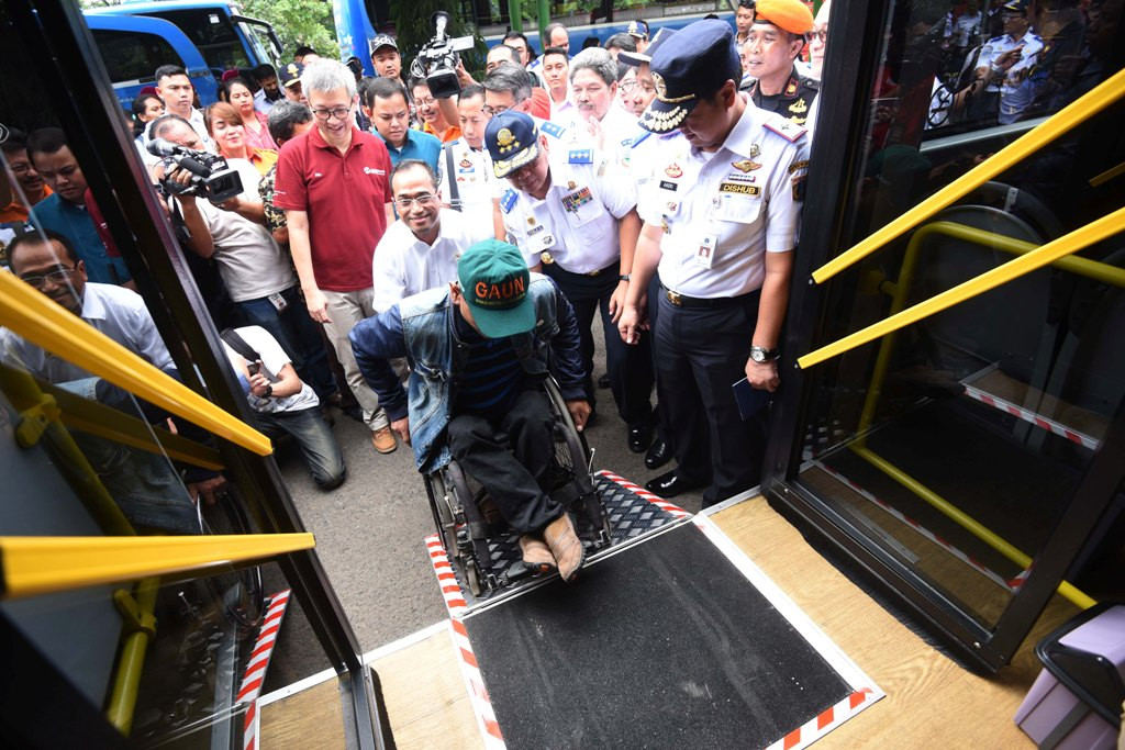 Menteri Perhubungan Budi Karya Sumadi (tengah) membantu seorang penyandang disabilitas untuk naik ke bus transjakarta dengan fasilitas jalur kursi roda saat melakukan inspeksi di Stasiun Gambir, Jakarta, Minggu (16/10). Foto: ANTARA FOTO/Akbar Nugroho Gum