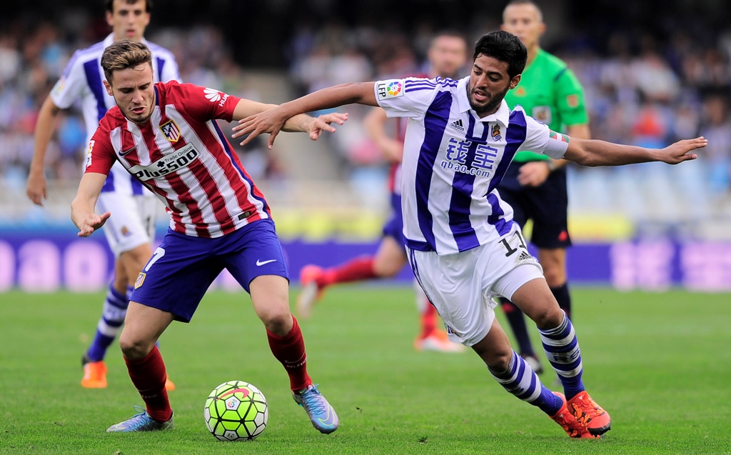Saul Niguez (Kiri) berduel dengan Carlos Vela (Kanan) (Foto: AFP/Ander Gillenea)