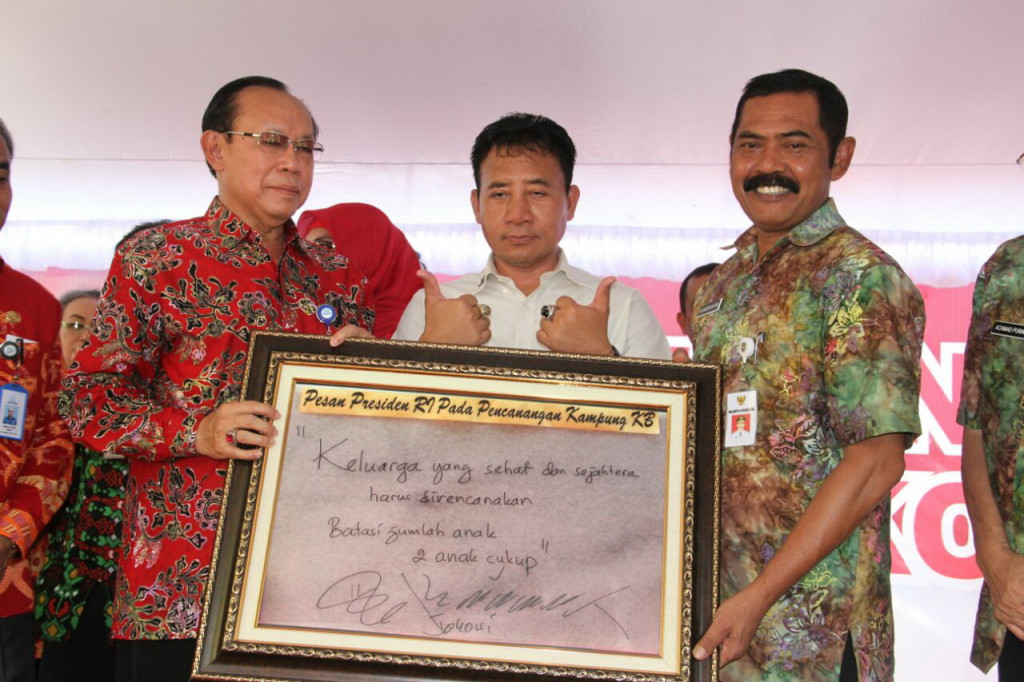 Kepala BKKBN Surya Chandra Surapaty menyerahkan pigura berisi pesan Presiden Jokowi ke Wali Kota Solo FX Hadi Rudyatmo saat peresmian Kampung KB di Pucangsawit, Jebres Solo, Jumat (11/11/2016). (Metrotvnews.com/Pythag Kurniati)