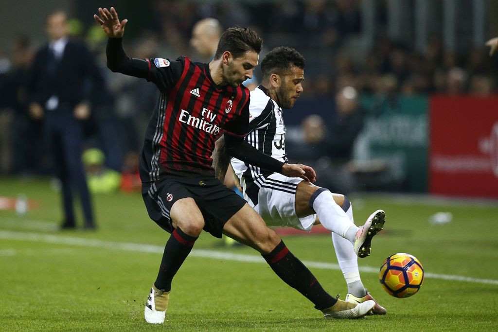 Mattia De Sciglio saat berebut bola dengan bek Juventus, Daniel Alves (Foto: AFP PHOTO / MARCO BERTORELLO)