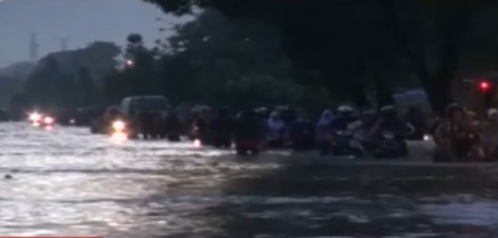 Sejumlah pengendara roda dua mendorong kendaraan melintasi banjir di Jalan Rancaekek, Bandung, Jabar, Senin (14/11/2016). (Metro TV)