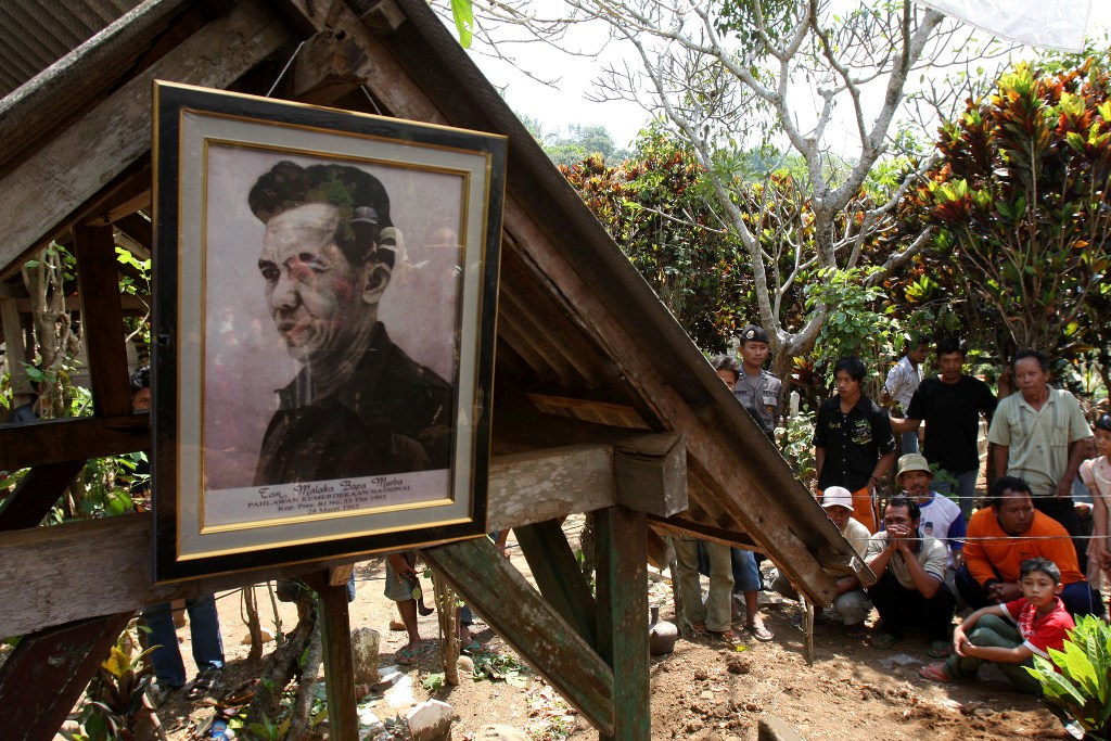 Masyarakat berdiri di samping makam yang diduga makam Tan Malaka yang sedang dibongkar untuk diteliti, di Desa Selo Panggung, Kecamatan Semen, Kediri, Jawa Timur, Sabtu (12/9/2009). Foto: Antara/Arief Priyono