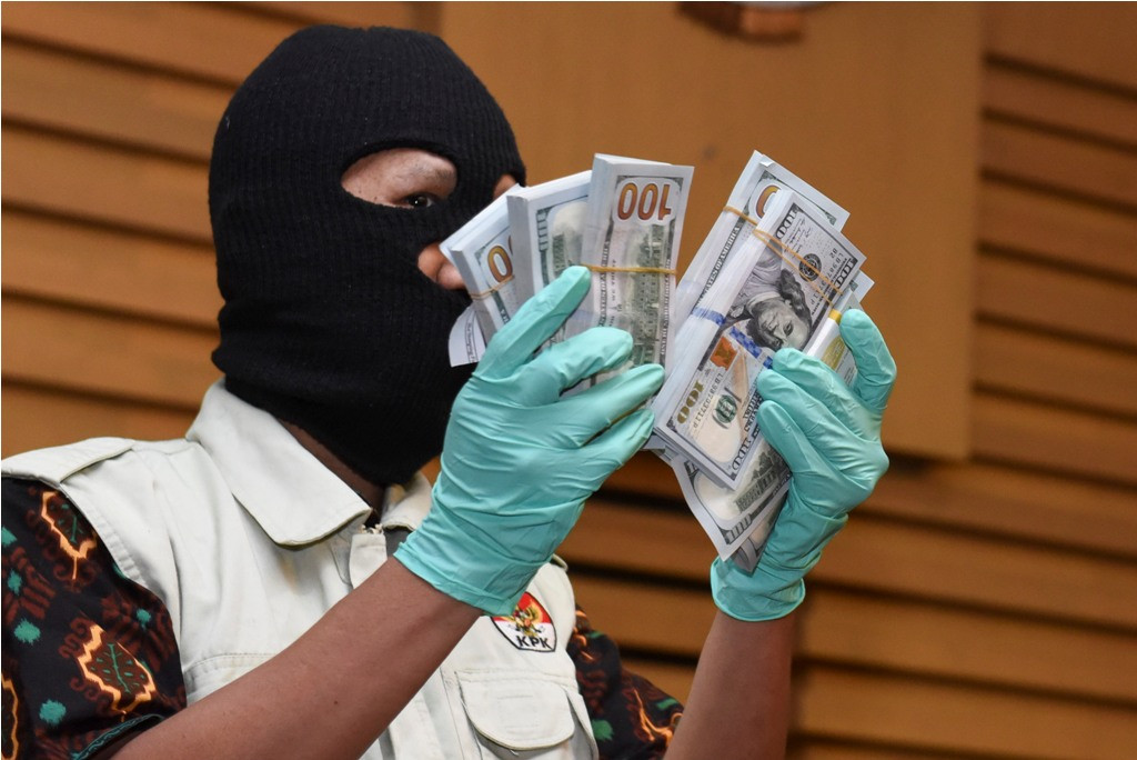 Petugas KPK menunjukkan barang bukti berupa uang dolar AS saat konferensi pers tentang OTT pejabat Ditjen Pajak. (Foto: Antara/Hafidz Mubarak).