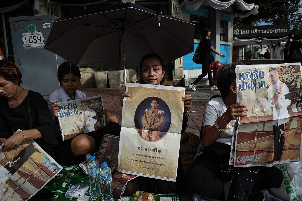 Warga memegang koran berisi foto raja baru Thailand, Maha Vajiralongkorn, 2 Desember 2016. (Foto: AFP/LILLIAN SUWANRUMPHA)