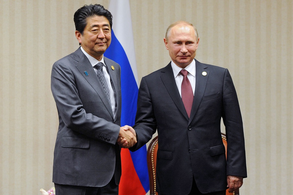 Presiden Rusia Vladimir Putin berjabat tangan dengan PM Jepang Shinzo Abe. (Foto: AFP)