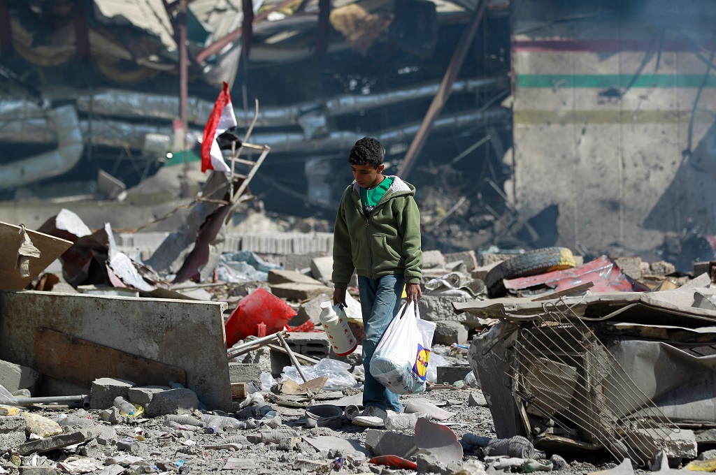 Seorang bocah berjalan di reruntuhan sebuah sekolah dan klub bowling di Sanaa, Yaman, 12 Februari 2016. (Foto: AFP/MOHAMMED HUWAIS)