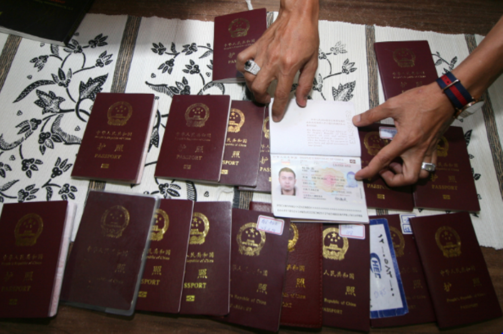Petugas Imigrasi memperlihatkan sejumlah paspor milik warga negara asing (WNA) asal Tionghoa yang diamankan karena menyalahi ijin tinggal. (ANT/{Prasetia Fauzani)