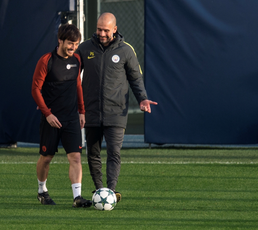 Pelatih Manchester City Pep Guardiola sedang memberikan instruksi kepada David Silva. (OLI SCARFF / AFP)