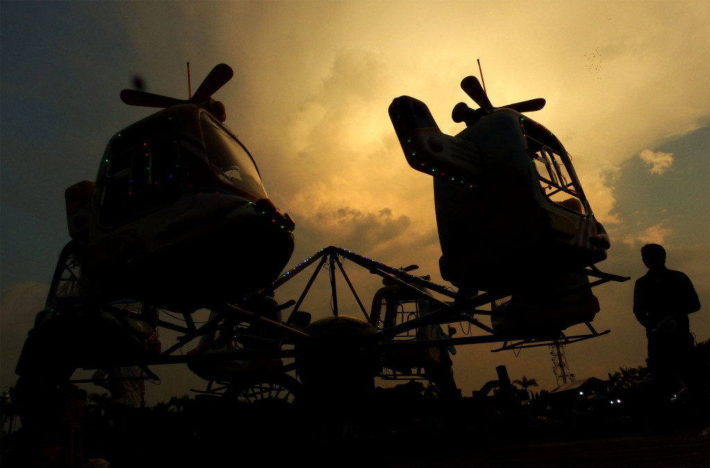 Warga memperhatikan wahana permainan berupa komedi putar mini di alun-alun Jombang, Jawa Timur, Senin (28/12/2015). Foto: Antara/Syaiful Arif