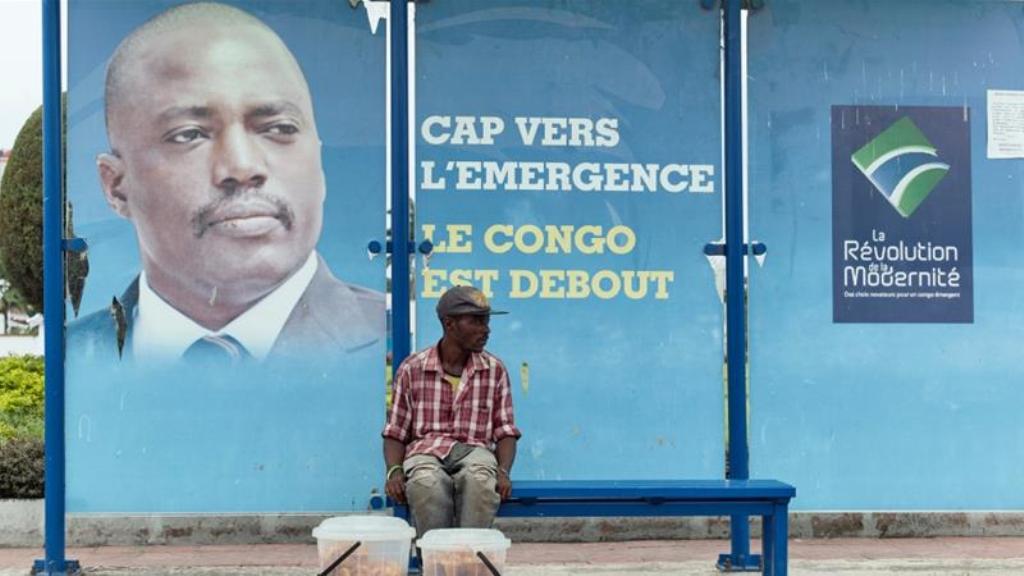 Seorang warga Kongo di hadapan poster Joseph Kabila (Foto: Reuters)