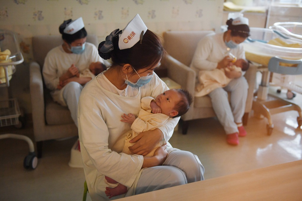 Perawat menggendong bayi di Beijing, Tiongkok, 13 Desember 2016. (Foto: AFP/GREG BAKER)