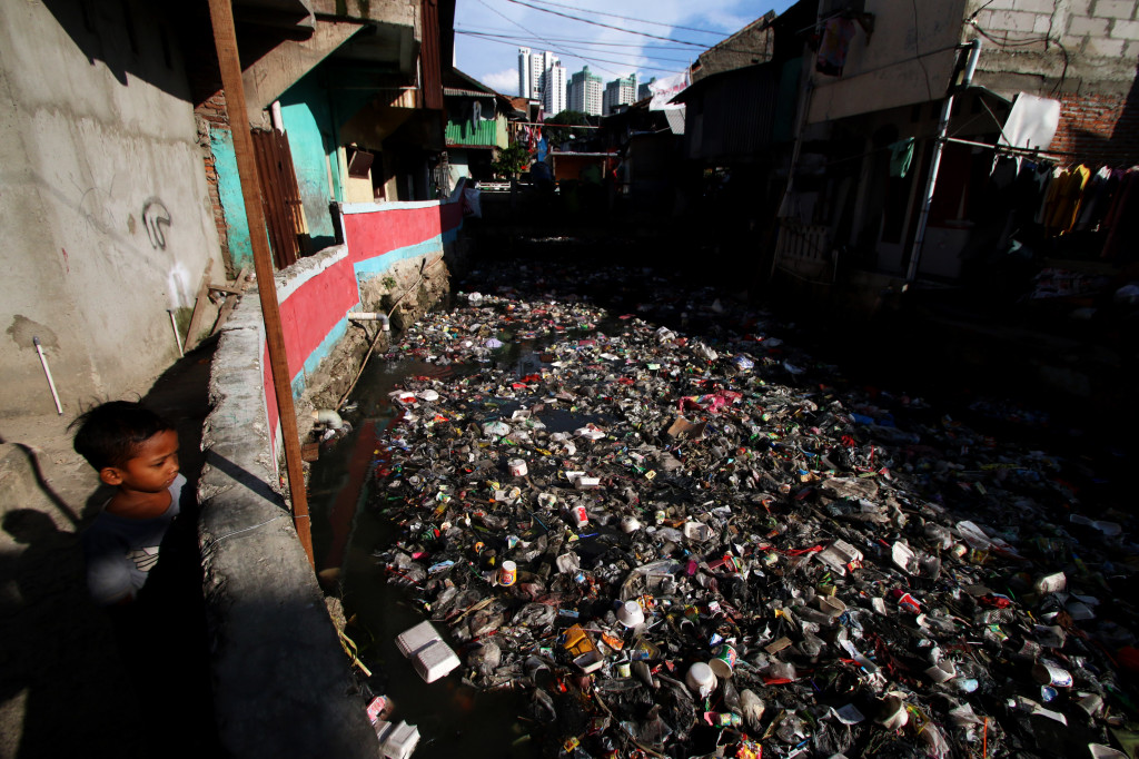 Seorang anak melihat sampah yang menumpuk di Kali Krukut, Kebun Melati, Tanah Abang, Jakarta, Senin (2/1/2017). Foto: Antara/Rivan Awal Lingga