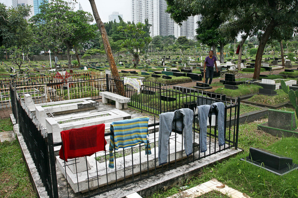  Pekerja merapikan makam di TPU Karet Bivak, Tanah Abang, Jakarta, Selasa (28/2/2017). Foto: MI/Galih Pradipta