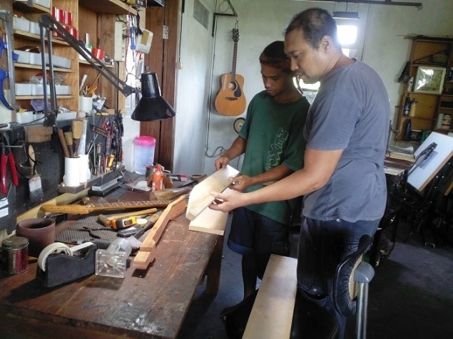 Perajin gitar, Noor Rahmat Wibowo, mengecek kegiatan produksi gitar di bengkelnya di Tangerang Selatan. (MTVN/Coki Lubis)