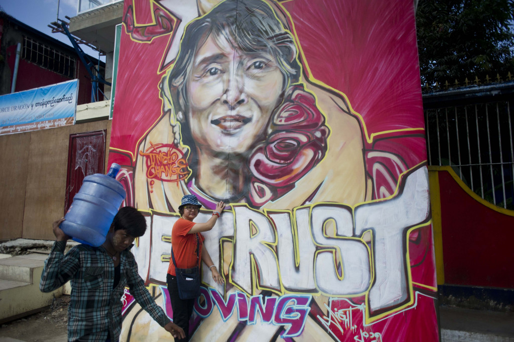 This file photo taken on November 13, 2015 shows a woman posing next to a graffiti depiction of Myanmar's opposition leader Aung San Suu Kyi outside the headquarters of the National League for Democracy party (NLD) in Yangon. (Photo:AFP/Ye Aung Thu)