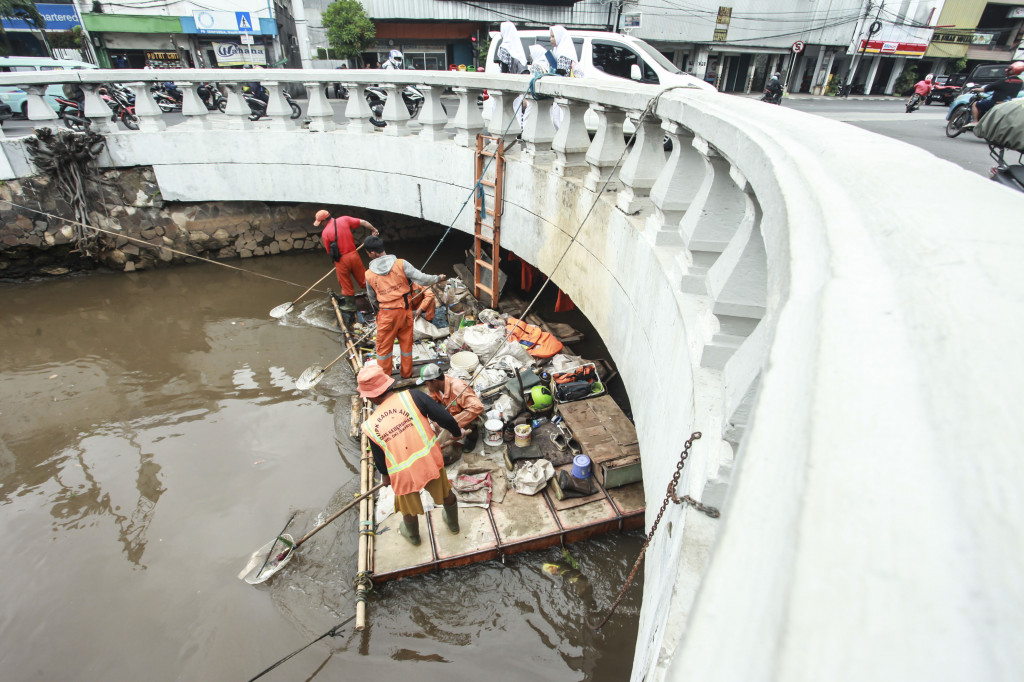 Pasukan Oranye mengambil sampah dan limbah di aliran Sungai Ciliwung di kawasan Harmoni, Jakarta, Kamis (9/2/2017). Foto: Antara/Muhammad Adimaja